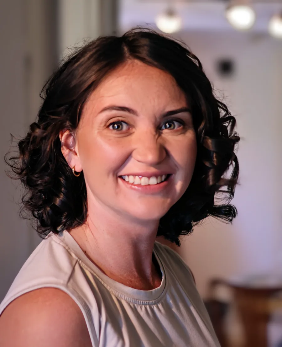 Megan, smiling, with dark curly hair